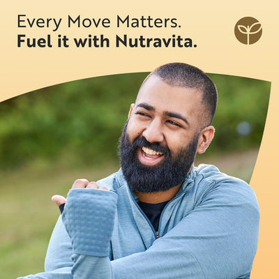 Man with a beard wearing a blue jacket outdoors with Nutravita advertisement text.